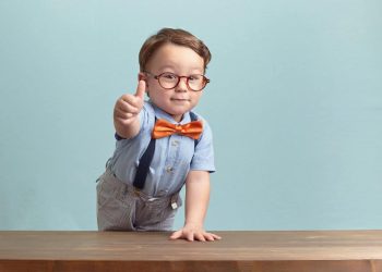 boy in bowtie and glasses gives positive thumbs up