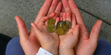 holding coins in hand for the future