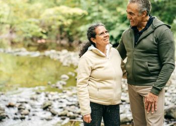 Two seniors walk in the forest
