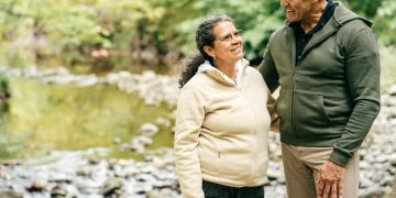 Two seniors walk in the forest