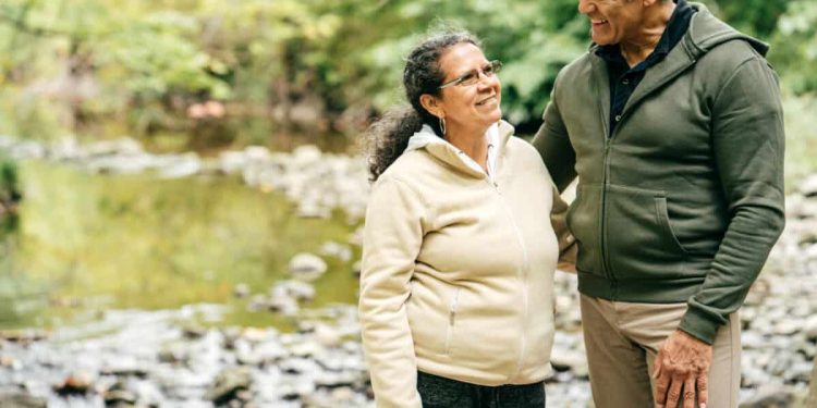 Two seniors walk in the forest