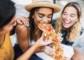 three friends eat pizza