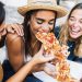 three friends eat pizza