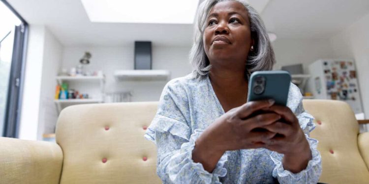 woman looks at iPhone