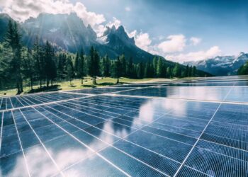 A solar cell panel generates power in a country mountain landscape.