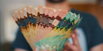 Person holds banknotes of Canadian dollars