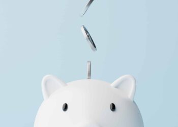 Silver coins fall into a piggy bank.