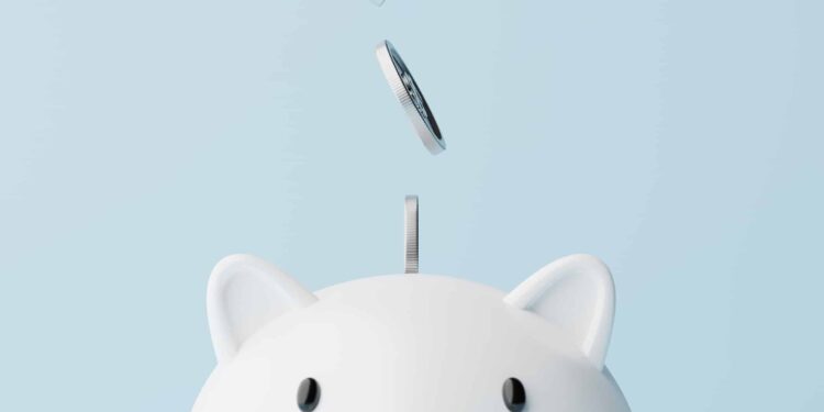 Silver coins fall into a piggy bank.