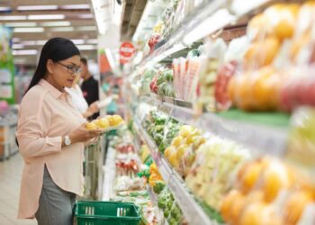 shopper chooses vegetables at grocery store