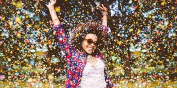 person enjoys shower of confetti outside