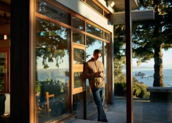 person on phone leaning against outside wall with scenic view at airbnb rental property
