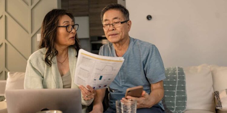 senior couple looks at investing statements
