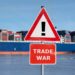 Warning sign with the text "Trade war" in front of container ship