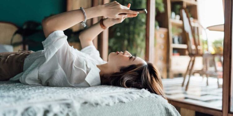 woman relaxes with phone