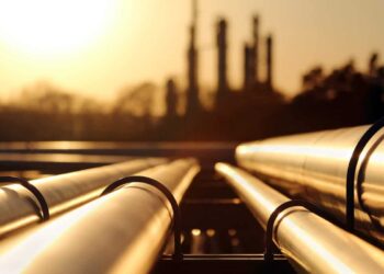 golden sunset in crude oil refinery with pipeline system